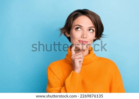 Photo of adorable nice lady finger touch chin look interested empty space isolated on blue color background