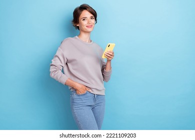 Photo Of Adorable Nice Woman Gray Sweatshirt Hand In Pocket Scrolling News Instagram Facebook Twitter Isolated On Blue Color Background