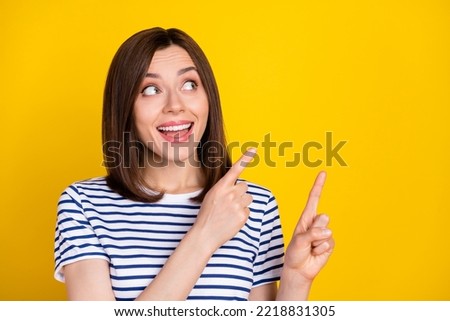 Photo of adorable optimistic stylish girl dressed striped t-shirt indicating empty space super sale isolated on yellow color background