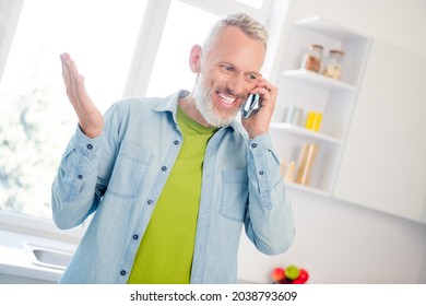 Photo of adorable positive aged gentleman wear denim shirt smiling talking modern device indoors house room - Powered by Shutterstock