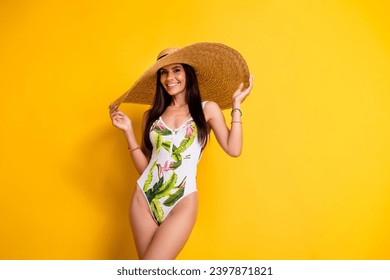 Photo of adorable pretty lady wear swimsuit big sun cap empty space isolated yellow color background