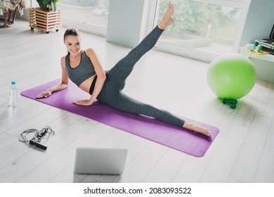 Photo of adorable sexy young lady wear sport outfit lying yoga carpet doing legs exercises smiling indoors home house