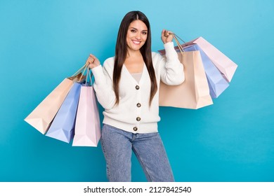 Photo of adorable shiny lady dressed white cardigan rising shoppers isolated blue color background