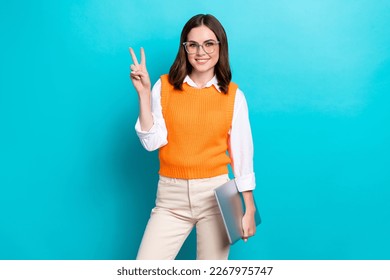 Photo of adorable smart clever lady wear stylish clothes hold netbook demonstrate v-sign isolated on cyan color background