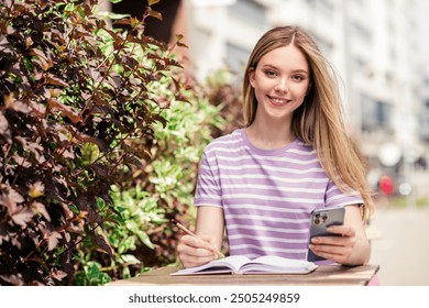 Photo of adorable sweet lady wear striped t-shirt sitting cafeteria typing modern device outdoors urban city street - Powered by Shutterstock