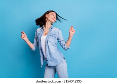 Photo of adorable sweet woman wear jeans shirt dancing empty space isolated blue color background - Powered by Shutterstock