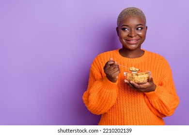 Photo of adorable young woman hold breakfast empty space dressed trendy autumn orange knitted sweater isolated on violet color background - Powered by Shutterstock