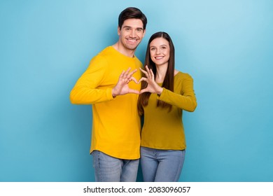 Photo of affectionate couple embrace make heart symbol wear yellow casual outfit isolated blue color background - Shutterstock ID 2083096057