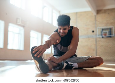 Photo of an african american basketball player doing some stretching exercises before practice. - Powered by Shutterstock