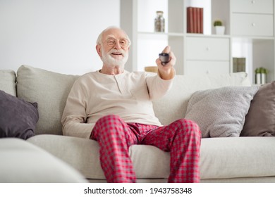 Photo Of Aged Man Pensioner Happy Positive Smile Sit Couch Home Watch Tv Cinema Switch Channel Remote Controller