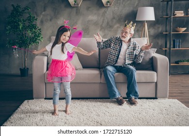 Photo of aged old grandpa little pretty granddaughter sit comfy sofa watch show acting fairy costume good mood stay house quarantine safety modern interior living room indoors