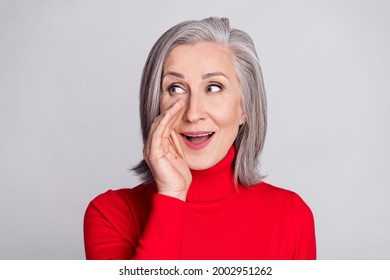 Photo of aged woman happy positive smile hand near mouth tell speak news secret isolated over grey color background
