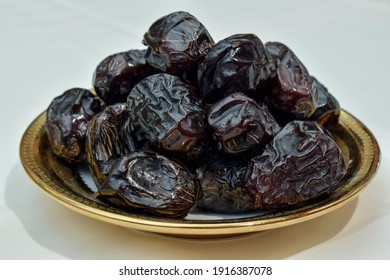 photo of ajwa dates in a large plate on a white background