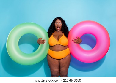 Photo of amazed obesity chubby large lady swim ocean hold inflatable rings isolated over blue color background