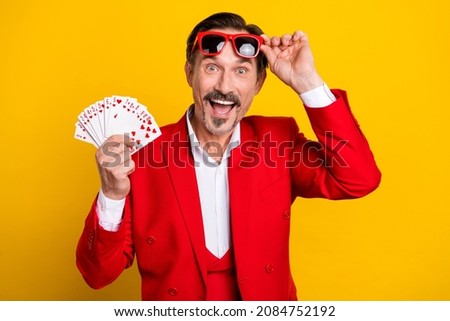Photo of amazed poker player in trendy luxury red suit win lots money success isolated on yellow color background