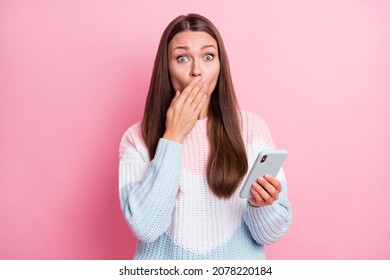 Photo of amazed shocked young woman mistake send message hold phone isolated on pink color background