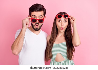 Photo of amazed surprised couple open mouth take off sunglass wait wear casual outfit isolated pink color background