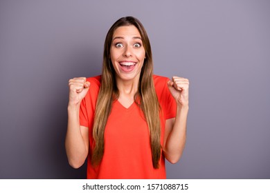 Photo Of Amazing Attractive Lady Raising Fists Yelling Loudly Not Believe Lucky Money Lottery Winning Impressed Wear Casual Orange T-shirt Isolated Grey Color Background