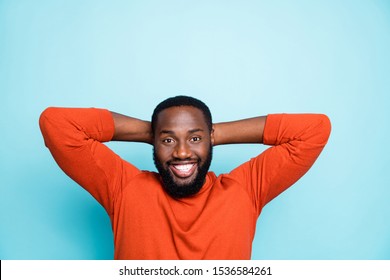 Photo Of Amazing Dark Skin Guy Holding Hands Behind Head Have Break Relaxing Nap Refreshment Moment Wear Casual Orange Pullover Isolated Blue Color Background