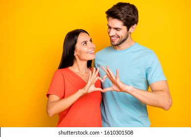 Photo Of Amazing Two People Guy Lady Celebrating Valentine Day Holding Fingers Heart Figure Shape Looking Eyes Wear Casual Blue Orange T-shirts Isolated Yellow Color Background