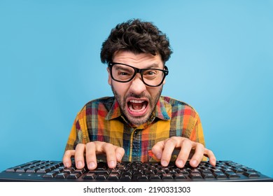 Photo of angry brunet guy type keyboard wear eyewear checkered shirt isolated on blue color background - Shutterstock ID 2190331303
