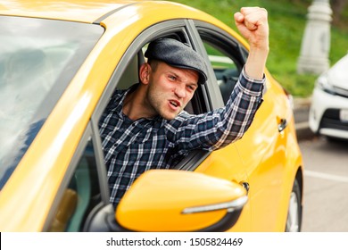 Photo of angry driver in plaid shirt sitting in yellow taxi on summer.