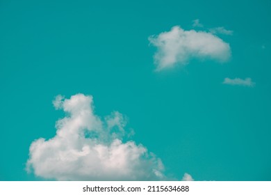 Photo of aqua blue sky with a group of white clouds in hard light contrast background. Abstract pop art photo of a surrealistic clean sky. Copy space artwork backdrop design awesome nature concept. - Shutterstock ID 2115634688