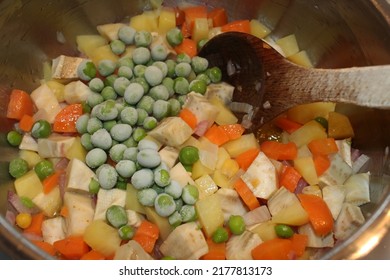 A Photo Of An Artichoke Dish With Peas In Olive Oil In A Pot