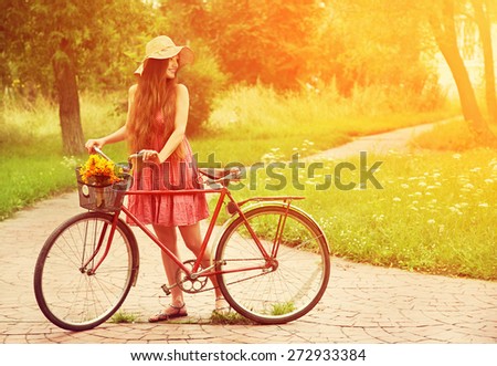 photo with artistic effect. vintage toning. film retro style. young woman in a hat with a bike in the park . Active people. Outdoors