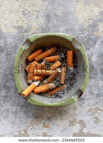 Photo of an ashtray full of ash and cigarette butts.