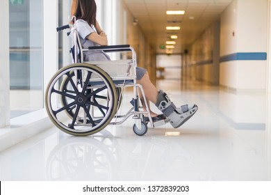 Photo of Asian female on wheel chair with orthopedic walking cast in hospital. Selective focus at the leg with shallow DOF and blurred background with copy space. The wheelchair for disability person. - Powered by Shutterstock