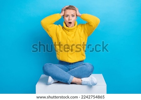 Photo of astonished anxious embarrassed lady sitting platform impressed bad news negative information isolated on blue color background