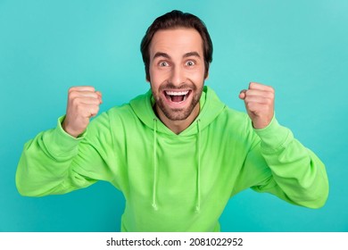 Photo of astonished guy celebrate successful bet goal attainment wear green hoodie isolated teal color background - Shutterstock ID 2081022952