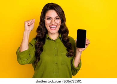 Photo of astonished lady hold phone touchscreen empty space rejoice triumph wear green shirt isolated yellow color background - Powered by Shutterstock