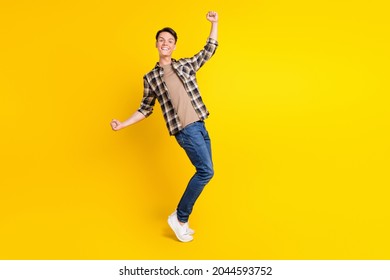 Photo of astonished positive guy celebrate victory wear plaid shirt jeans shoes isolated yellow color background - Shutterstock ID 2044593752
