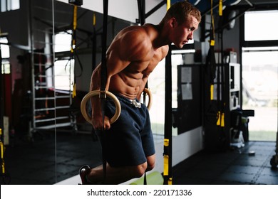 Photo of an athlete working out his muscles on rings - Powered by Shutterstock