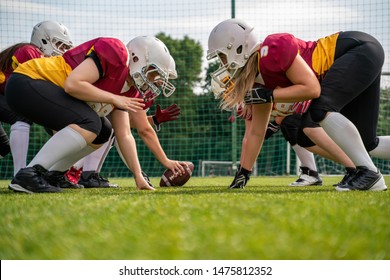 Photo of athletes wearing helmets playing american football on sports field