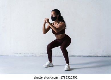 Photo Of Athletic African American Woman In Face Mask Doing Exercise While Working Out Indoors