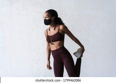 Photo Of Athletic African American Woman In Face Mask Doing Exercise While Working Out Indoors