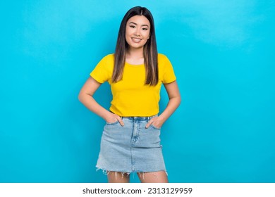 Photo of attractive asian girl model wear yellow t-shirt denim short skirt advertise clothes isolated blue teal color background