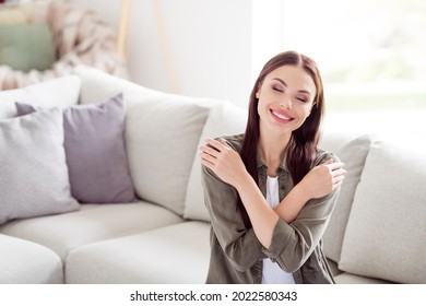 Photo Of Attractive Beautiful Young Woman Dressed Khaki Shirt Hugging Herself Indoors Home Room