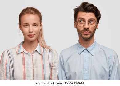 Photo Of Attractive Blonde Woman With Pony Tail, Curious Unshaven Guy Stand Shoulder To Shoulder Against White Background, Have Friendly Relationships. Two Colleagues Meet Together For Making Project