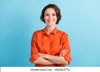 Photo Of Attractive Bossy Lady Bobbed Hairdo Arms Crossed Self-confident Person Worker Friendly Smile White Teeth Good Mood Wear Orange Office Shirt Isolated Blue Color Background