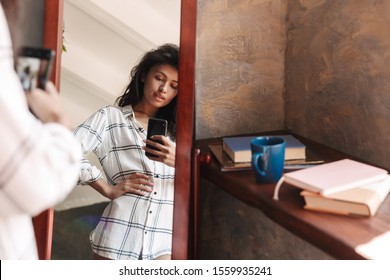 Photo Of Attractive Brunette Woman Wearing Shirt Taking Selfie Photo And Looking At Mirror In Apartment