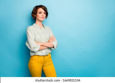 Photo of attractive business lady short hairstyle not smiling serious reliable person arms crossed wear casual green shirt yellow trousers isolated blue color background
