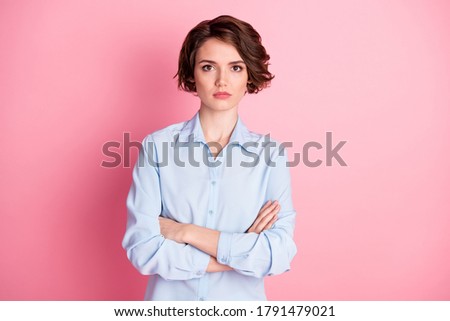 Photo of attractive charming business lady serious expression not smiling hold arms crossed good mood self-confident successful worker wear blue shirt isolated pink color background