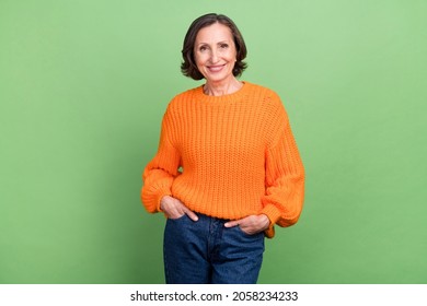 Photo of attractive cool grandma hands in pocket good mood casual outfit isolated over green color background