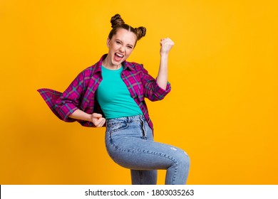 Photo Of Attractive Excited Crazy Teen Lady Two Funny Buns Good Mood Cheering Football Team Sports Supporter Raise Fists Wear Casual Plaid Shirt Isolated Yellow Bright Color Background