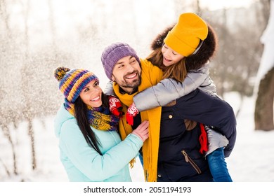Photo of attractive family mom dad daughter piggyback happy positive smile snowy winter day walk park