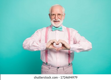 Photo Of Attractive Grandpa Making Heart Figure Fingers Hands Inviting Wife Romance Date Wear Specs Pink Shirt Suspenders Bow Tie Trousers Isolated Teal Color Background